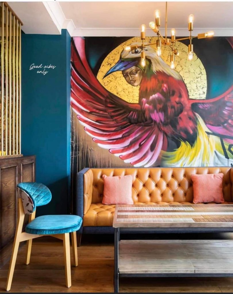 Large-scale bird restaurant mural featuring hand-painted wildlife artwork within a contemporary commercial interior.