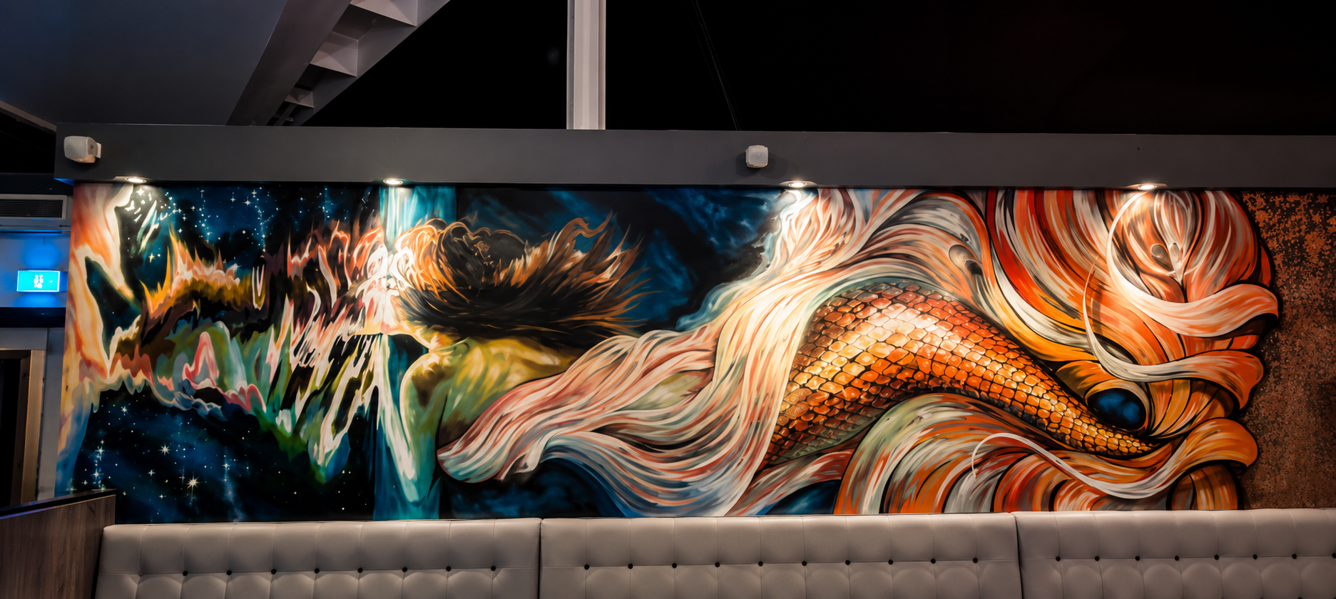 Spray-painted feature wall mural featuring flowing mermaid's fish scales, abstract movement and cosmic elements within a contemporary hospitality venue