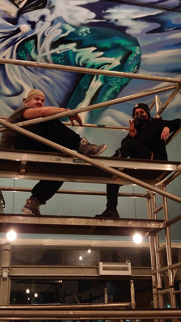 two restaurant mural artist devon, urban gypset mid project up on a scaffolding